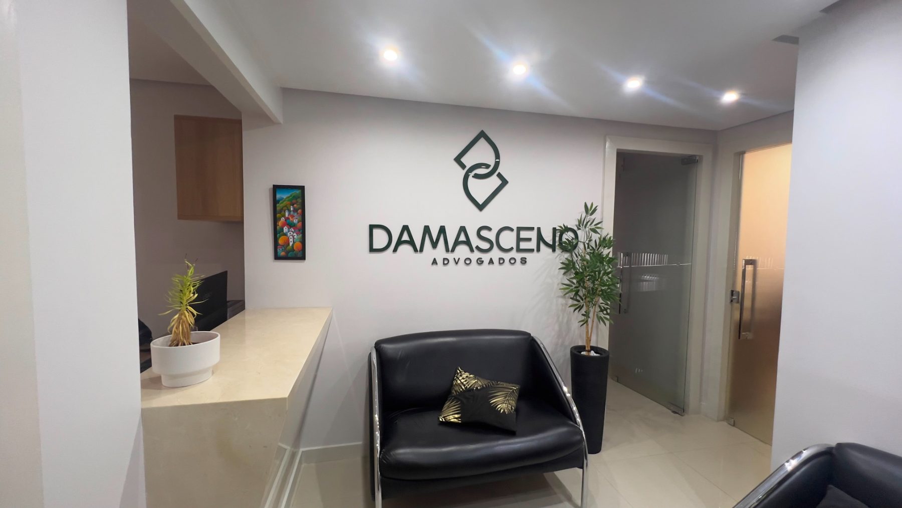 Recepção do escritório Damasceno Advogados, com a marca aplicada na parede